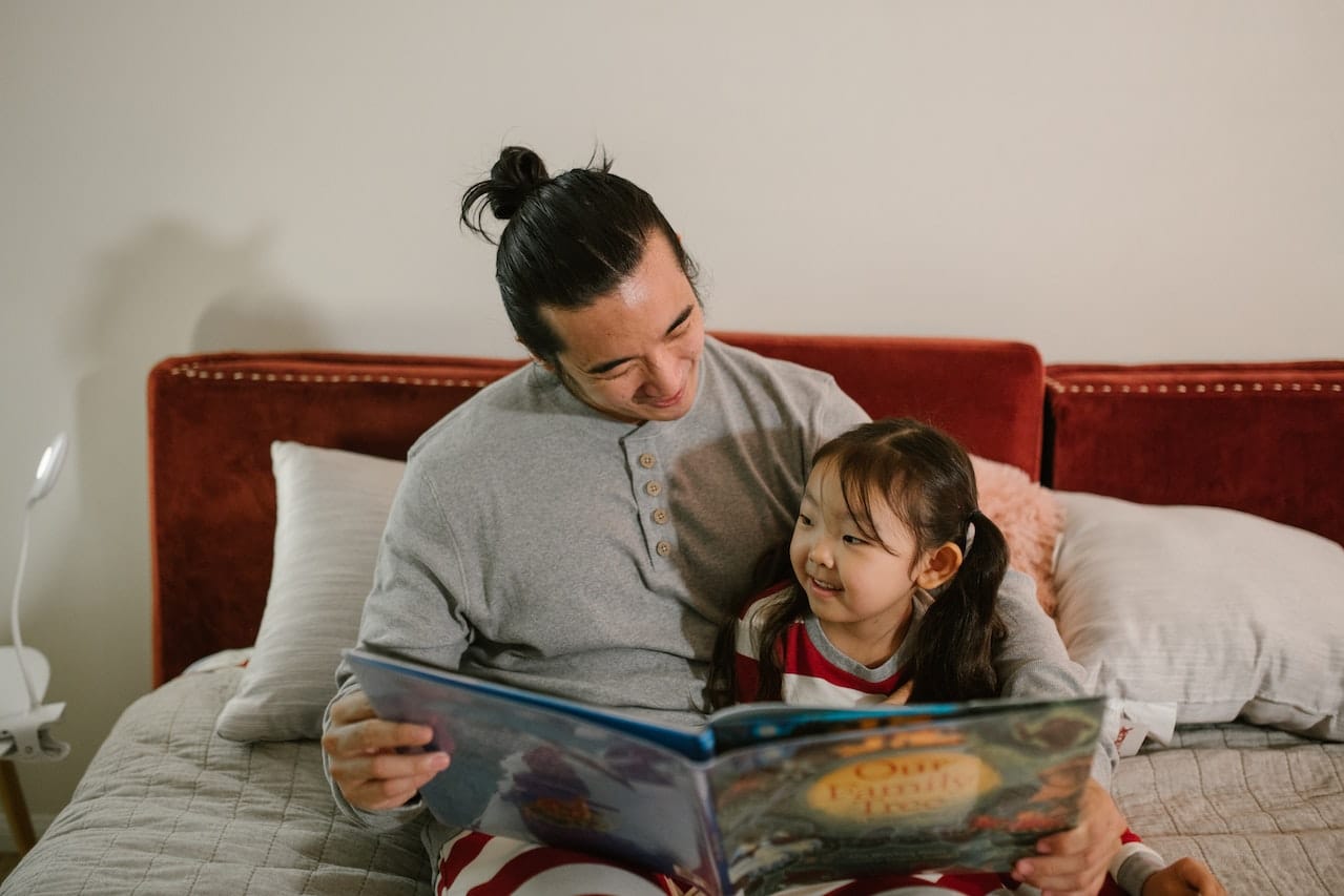 dad reading book with daughter
