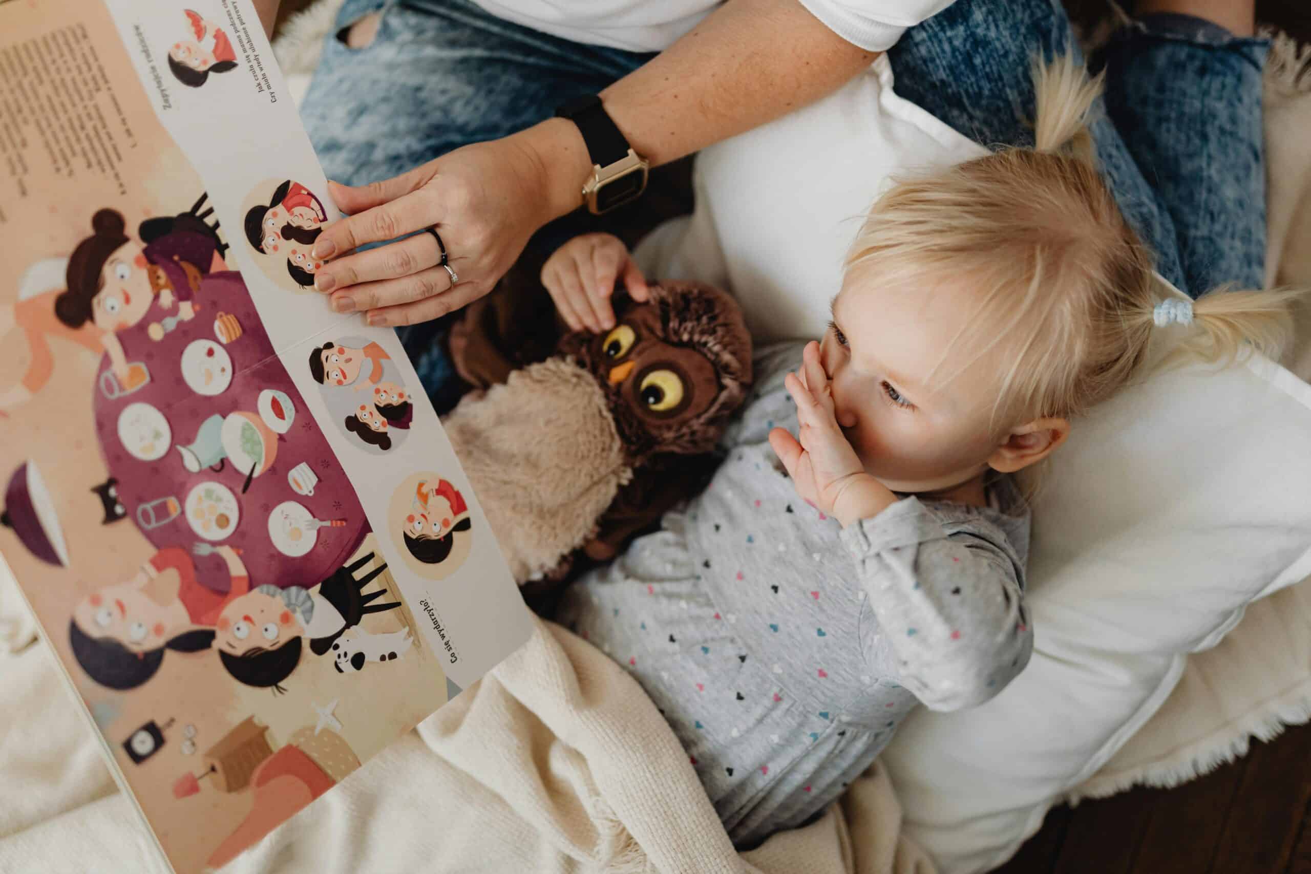 A parent reads a storybook with their daughter.