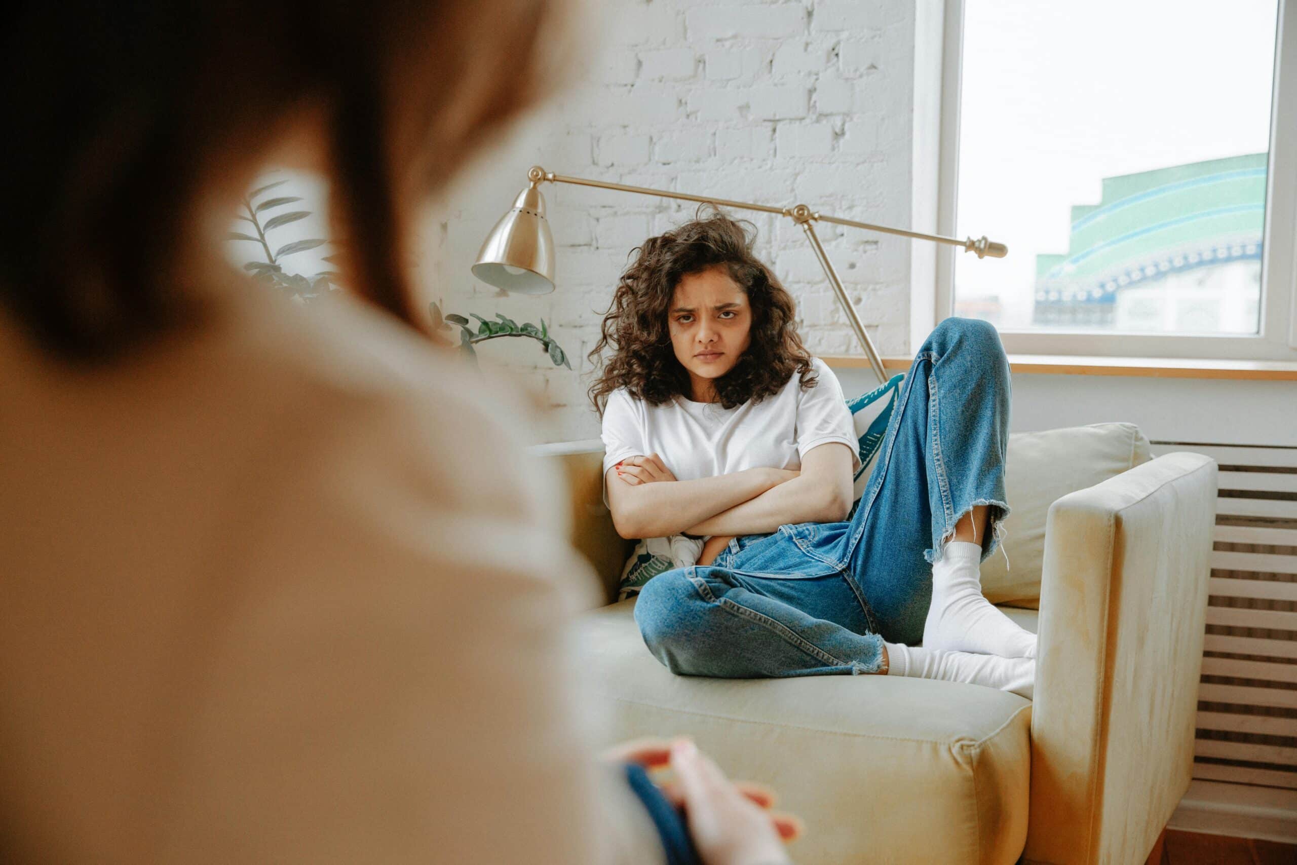 A daughter looks frustratingly at her mother at the other end of the room.
