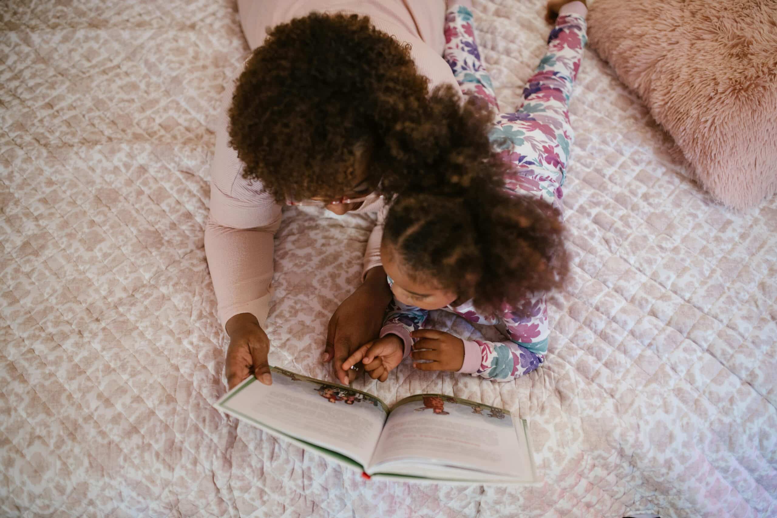 A mother and daughter read a storybook together.